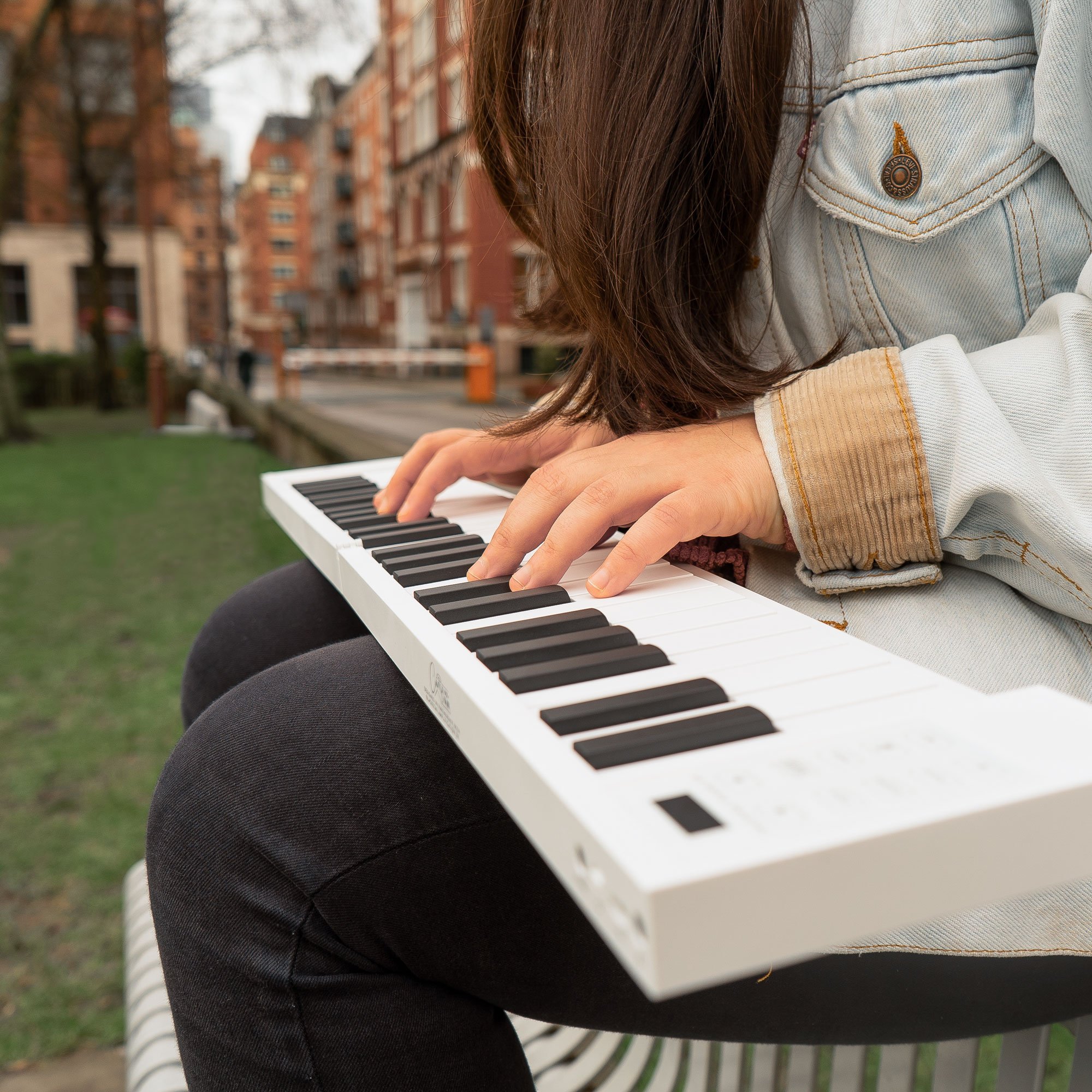 A child playing the Carry-on 49 Key folding piano outdoors.
